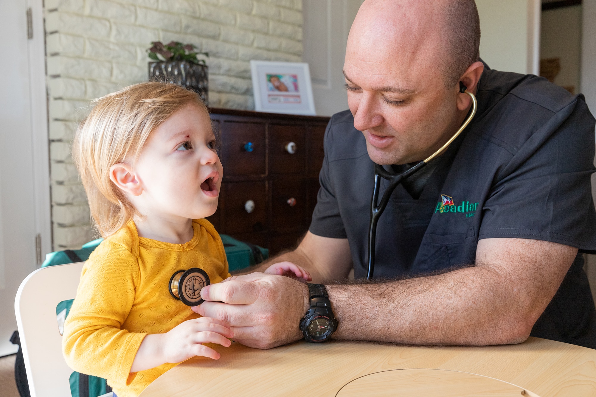 Acadian Health employee examining a child at home